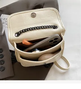 Internal view of beige quilted bag showing multi-layer compartments and daily essentials