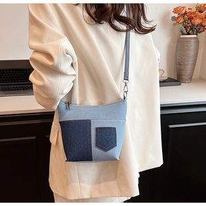 Details der blauen Patchwork-Denim-Umhängetasche mit orangefarbenen Nähten und Silberbeschlägen