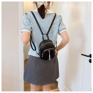 Detailansicht eines schwarzen Mini-Rucksacks aus Leder mit silbernen Reißverschlüssen