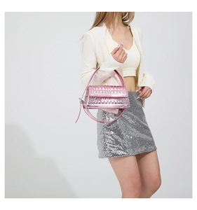 Detail of glossy pink crossbody bag with geometric texture on white background