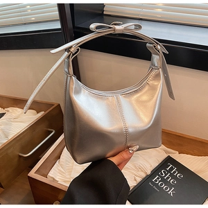 Silver crescent bucket bag featuring metallic leather and a delicate bow handle detail