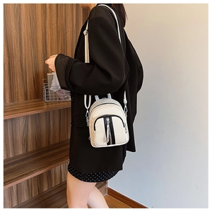 Detailansicht eines weißen Mini-Rucksacks aus Leder mit schwarzen Reißverschluss-Details