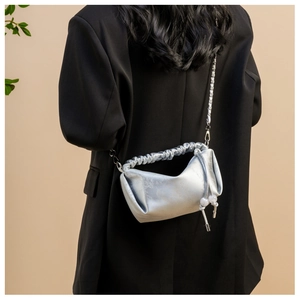 Détail du sac plissé argenté avec texture quadrillée et bandoulière en chaîne métallique