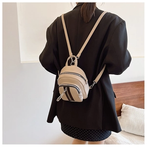 Detailansicht beige Leder-Minirucksack mit Herz-Reißverschlüssen an einem Model