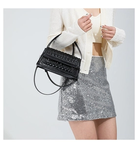 Close-up of black crocodile pattern texture and glossy finish on the leather handbag