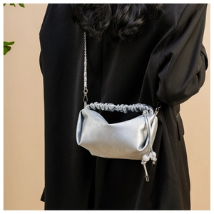 Détails du sac plissé argenté avec texture métallique brillante et breloques perlées