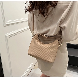 Vue détaillée du sac à bandoulière plissé beige avec ferrures dorées et texture fine
