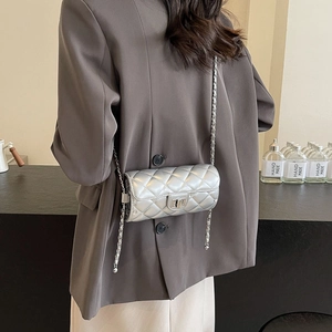 Sac bandoulière cylindrique argenté avec matelassage en losanges et fermoir tournant