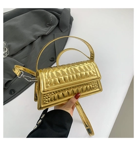 Close-up of golden metallic handbag featuring embossed square crocodile texture and strap