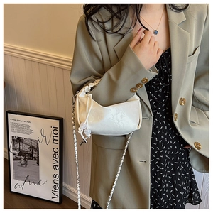 Détail du sac à cordon en jacquard blanc avec tissu texturé et bandoulière tressée