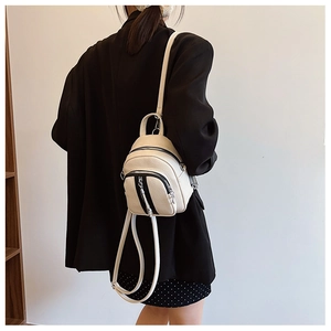 Detail eines cremefarbenen Mini-Rucksacks aus Leder mit Trägern und Reißverschluss-Akzenten
