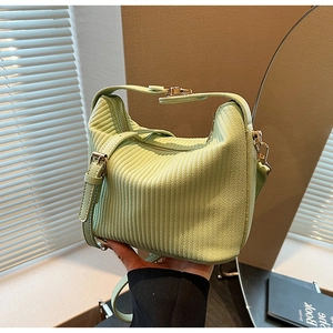 Détail du sac à main plissé vert clair avec ferrures dorées et tissu texturé