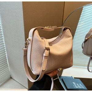 Vue détaillée du sac à main plissé rose avec ferrures dorées et texture verticale