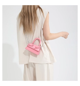Close-up of pink mini bag with elegant bow design and delicate silver chain strap