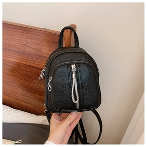 Detail eines Mini-Rucksacks aus schwarzem Kieselleder mit silbernen Reißverschlüssen