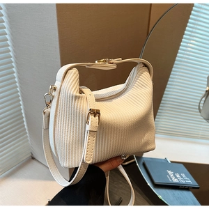 Gros plan sur la texture en velours côtelé blanc et les boucles métalliques du sac