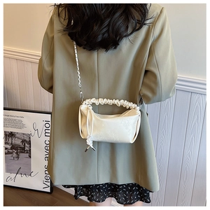 Détail du sac nuage plissé crème avec tissu texturé et bandoulière en chaîne cuir