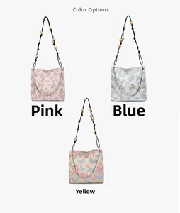 Detailansicht der bestickten Schmetterlings-Stofftaschen in Rosa, Blau und Gelb