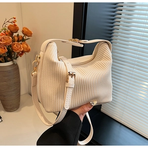 Texture détaillée du sac hobo en velours côtelé écru avec garnitures dorées élégantes