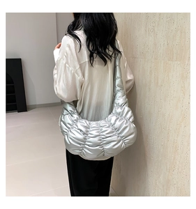 Detail showing the quilted silver texture and ruched design of the crescent shoulder bag