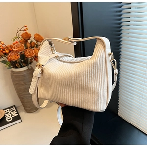 Détail du sac à main plissé blanc avec textures verticales et finitions dorées fines