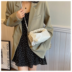 Détail du sac nuage plissé blanc cassé avec chaîne argentée porté par un mannequin