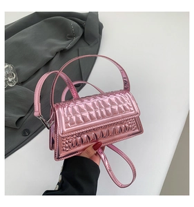 Detail of glossy pink embossed handbag with crocodile pattern and detachable strap