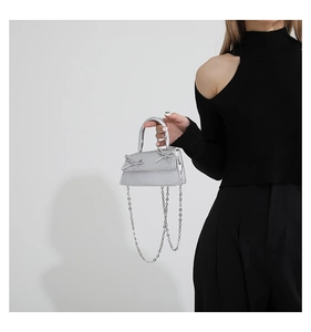 Detailed view of a silver mini bag with double bows and a sleek metallic chain strap