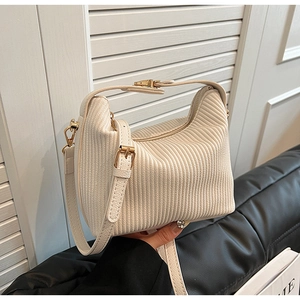 Détail du sac hobo beige plissé avec garnitures dorées et bandoulière réglable tendance