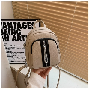 Detailaufnahme der beigefarbenen Mini-Rucksacktasche mit Metallquasten-Reißverschluss