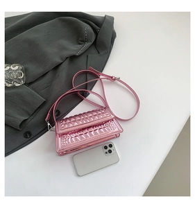 Detailed macro view of pink metallic mini handbag with croc-embossed texture and shoulder strap