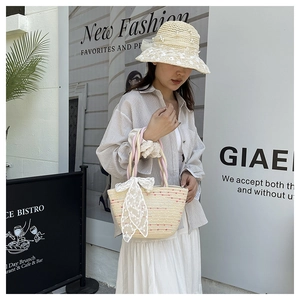 Close-up of beach straw bag and sun hat set with lace bow and floral embroidery details