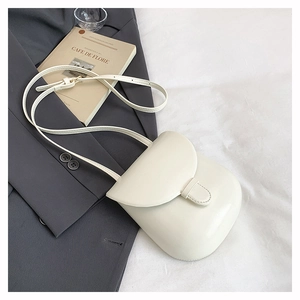 Detailed view of off-white retro saddle crossbody bag on a minimalist background
