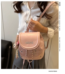 Vue détaillée du mini sac à dos rose avec broderie IBCMB, chaîne et pendentif chiot