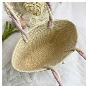 Top view of handwoven cotton rope tote with pink handles and internal storage detail