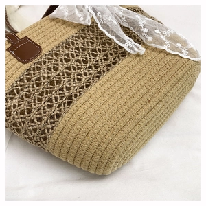 Close-up of woven straw tote bag showing beige textures and brown hollow patterns