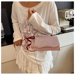 Détail de la pochette de soirée rose pailletée avec poignée dorée et perles