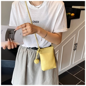 Detail of bright yellow leather phone bag with pebble texture and knotted shoulder strap