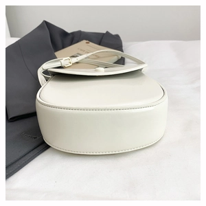 Detail view of the white saddle bag showing sturdy stitched base and leather texture