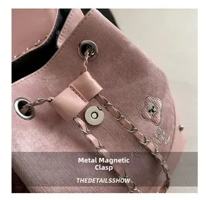 Close-up of pink bucket backpack with dog embroidery and silver metal chain drawstring