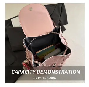 Pink corduroy mini backpack capacity display showing books and interior storage