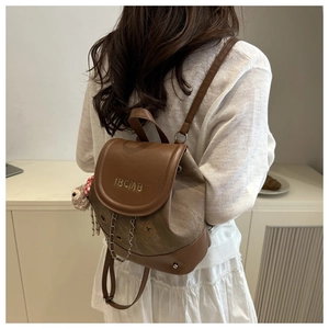 Détail du mini sac à dos avec patchwork de cuir marron, broderie dorée et bijou d'ours