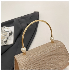 Détail du sac à main pailleté champagne avec poignée métallique ornée de perles chic
