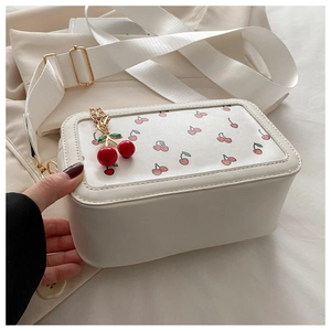 Detalle del bolso de hombro blanco rectangular con estampado de cerezas y colgante 3D