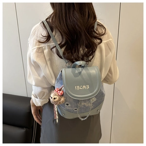 Vue détaillée du mini sac à dos en denim avec broderies et pendentif peluche mignon