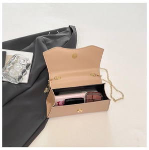 Vue intérieure du sac bandoulière en cuir beige montrant l'espace pour le maquillage