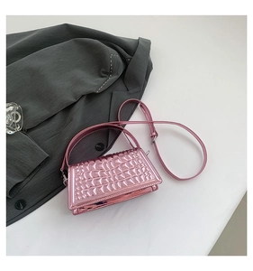 Detail of shiny metallic pink rectangle handbag with textured rhombus pattern