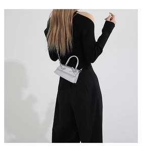 Silver mini crossbody bag featuring metallic bows and sleek chain strap detail