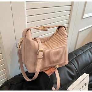 Détail de la texture en cuir plissé rose clair et des finitions dorées du sac hobo