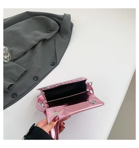 Close-up of pink metallic handbag with crocodile texture and silver magnetic clasp